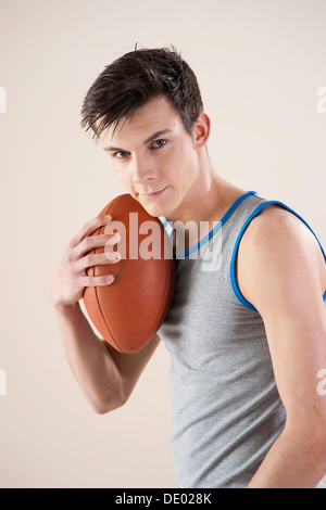 Young man holding a football in his hand Stock Photo