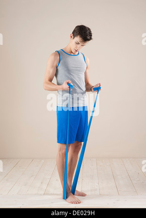 Young man doing fitness exercises with a resistance band Stock Photo