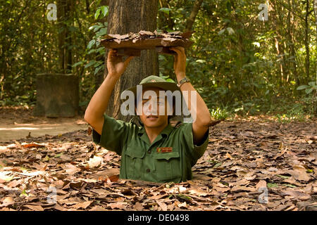 Vietnam soldier showing the entrance to the tunnel system of the Viet Cong in Chu Chi, Vietnam, Asia Stock Photo