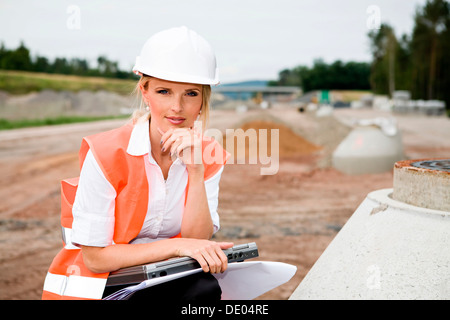 A young female constructor at building of a new motorway Stock Photo
