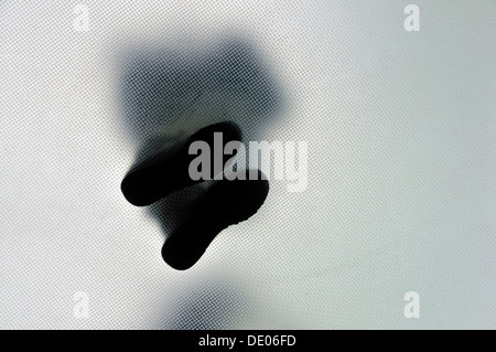 Anonymous person standing with legs crossed, from below Stock Photo