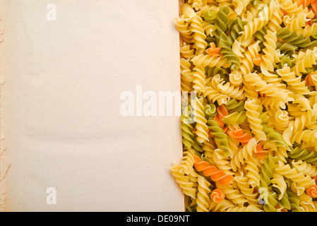 Italian fusilli or rotini and open recipe book with blank page Stock Photo
