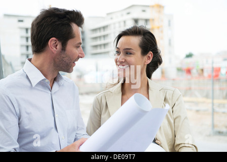 Architects discussing blueprint in construction site Stock Photo
