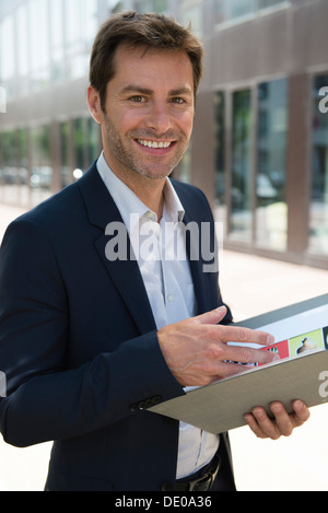 Businessman holding folder, portrait Stock Photo