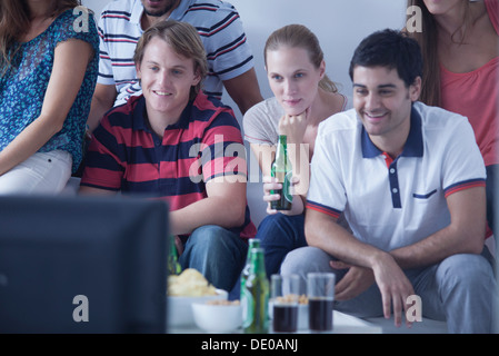 Friends watching sports match on television together Stock Photo