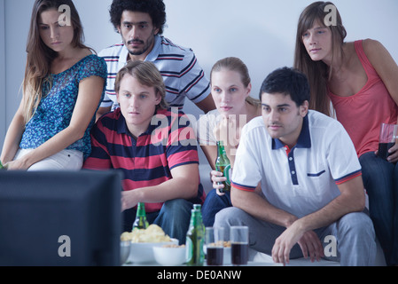 Friends watching sports match on television together Stock Photo