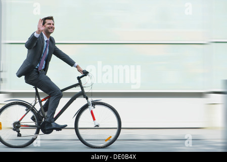 Businessman riding bicycle Stock Photo