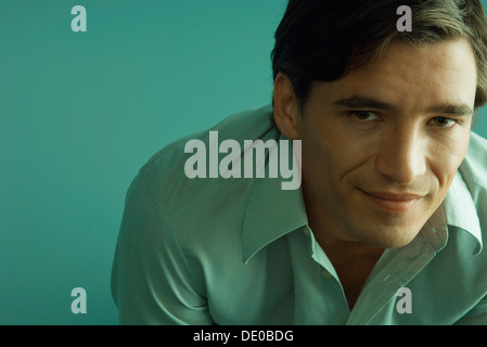 Man smiling, leaning forward, looking at camera Stock Photo