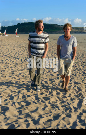 Two laughing young men are walking along the beach on the Atlantic coast, Bretagne, France, Europe Stock Photo