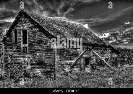 An HDR, black and white photo, of an old rustic wooden shed against dramatic looking sky. Stock Photo