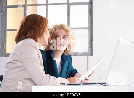 Manager working in an office with a trainee at the computer Stock Photo