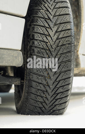 Winter tyre of a car on a snow-covered road Stock Photo