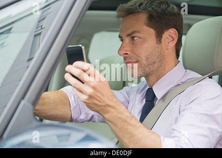 Man using smartphone while driving Stock Photo