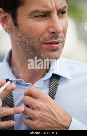 Businessman putting on necktie Stock Photo