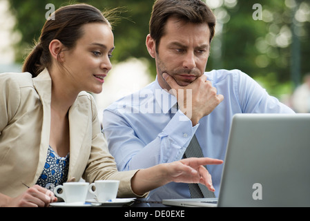 Business associates collaborating on project using laptop computer Stock Photo