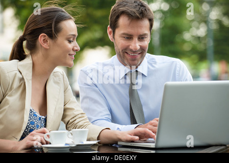Business associates working together using laptop computer outdoors Stock Photo