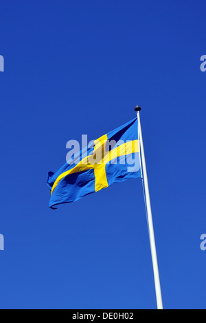 The Swedish flag flying against a bright blue sky. Stock Photo