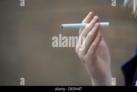 A girl holds an electronic cigarette in her hand. Stock Photo