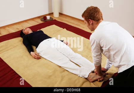 Young woman doing relaxation exercises with a Qigong coach Stock Photo