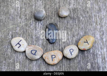 Stones with letters forming a smiley face, lettering 'happy' Stock Photo