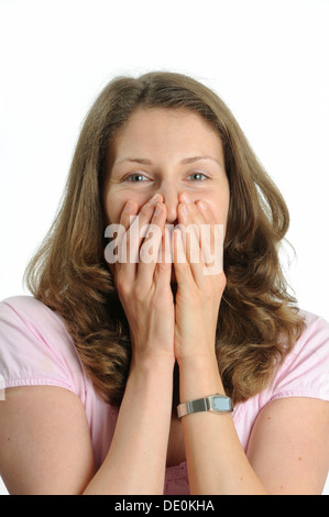 Smiling young woman holding hands in front of her face Stock Photo