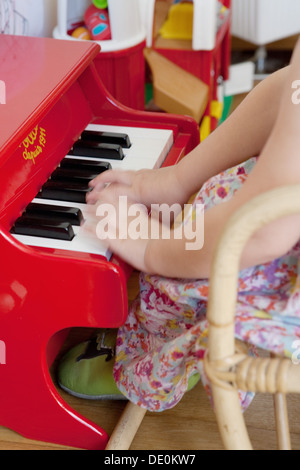 Little girl playing toy piano, cropped Stock Photo