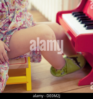 Little girl playing with toy piano, cropped Stock Photo