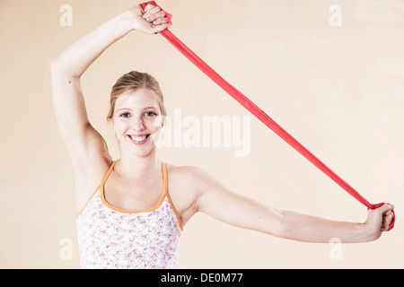 Young woman doing exercises with a Theraband Stock Photo