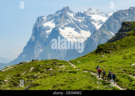 Hikers on the Eiger Trail near Grindelwald Switzerland with the Wetterhorn behind Stock Photo
