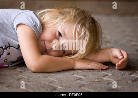 Smiling girl, 4, lying on the ground Stock Photo