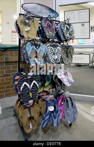 Colorful flip flops, sandals and beach shoes for sale on a display rack outside a store. Stock Photo