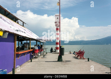 Fishermen fish while clients sit at outdoor bar of Tequila Republic lakeside bar and restaurant on the shore of Lake Chapala. Stock Photo