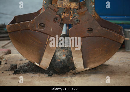 Bomb from the Second World War between the buckets of an excavator, discovered during dredging works Stock Photo