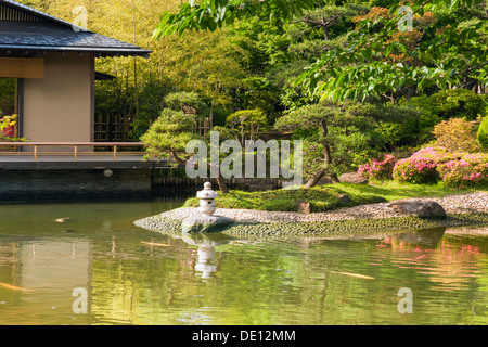 scenic Japanese zen garden with pond and small stone lantern by summer Stock Photo