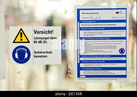 Sign in German, Caution noise levels above 85 dB, use hearing protection, company guidelines for use of hearing protection in Stock Photo