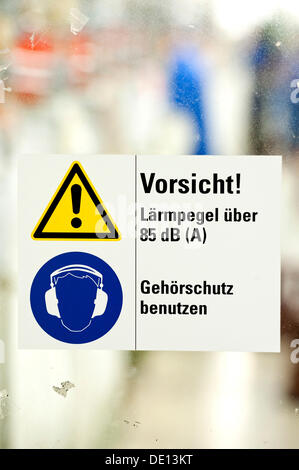 Sign in German, Caution noise levels above 85 dB, use hearing protection, company guidelines for use of hearing protection in Stock Photo