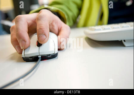 Workers hand on a computer scroll mouse. Stock Photo