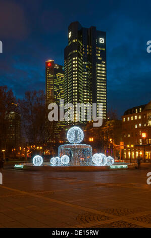 Illuminated Lucae Fountain on Opernplatz square in front of Trianon high-rise building and the Deutsche Bank Twin Towers Stock Photo