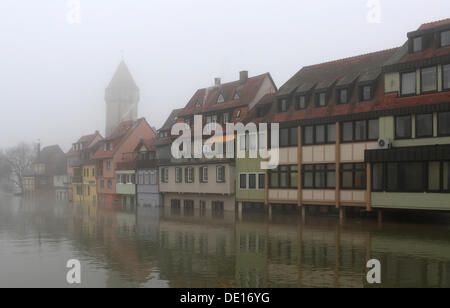Floodwaters and fog, buildings on the bank of the Tauber river, seen from the Tauber river bridge on Bahnhofstrasse street from Stock Photo