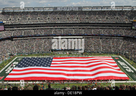 US military personnel representing each branch of service unfurl the American flag during the pregame ceremony at MetLife Stadium September 8, 2013 in East Rutherford, NJ. Stock Photo