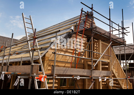 self building house, constructing green oak timber framed garage, external scaffolding around structure Stock Photo