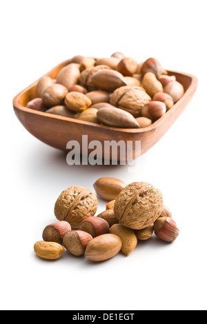 various unpeeled nuts in wooden bowl on white background Stock Photo