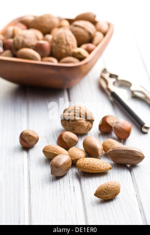 various unpeeled nuts on wooden table Stock Photo