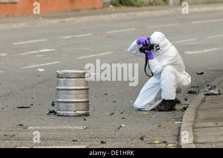 Belfast, Northern Ireland. 10th September 2013 - A PSNI forensics officer photographs the beer keg which was in the rear of an abandoned vehicle and lead to army ATO carrying out a controlled explosion. Credit:  Stephen Barnes/Alamy Live News Stock Photo