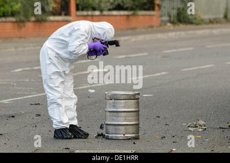 Belfast, Northern Ireland. 10th September 2013 - A PSNI forensics officer photographs the beer keg which was in the rear of an abandoned vehicle and lead to army ATO carrying out a controlled explosion. Credit:  Stephen Barnes/Alamy Live News Stock Photo