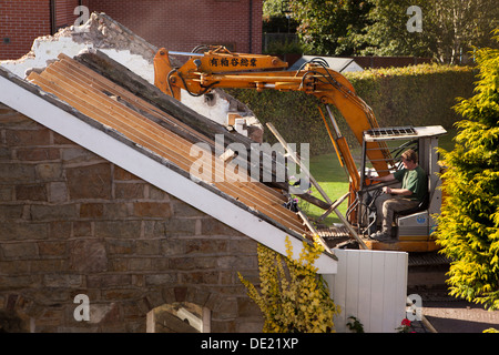 self building house, demolishing roof of old stone built outbuilding to clear site ready for building new house Stock Photo