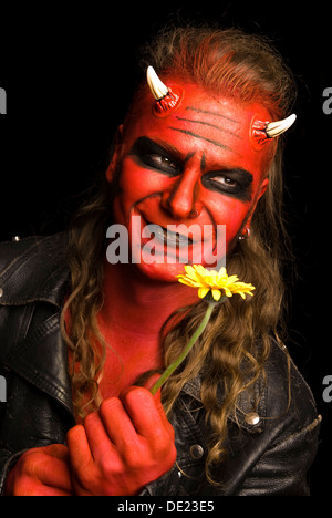 Red devil with yellow flower Stock Photo