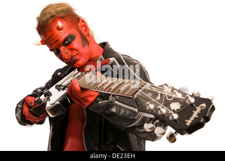 Red Devil pointing an electric guitar at the viewer Stock Photo