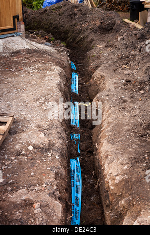 self building house, Blue Caution Water Main Below warning tape above buried water supply pipe Stock Photo