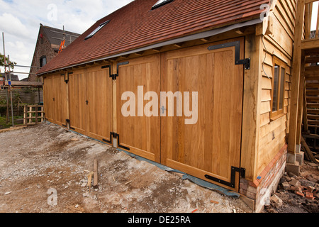 self building house, constructing green oak timber framed 3 bay garage, solid oak doors Stock Photo